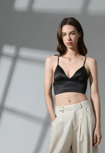 Detailed view of backless black satin bralette with thin straps and V-neckline