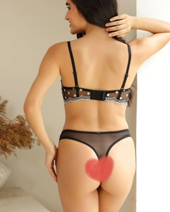 Detail view of the black polka dot lace mesh back design and floral lace edging on lingerie