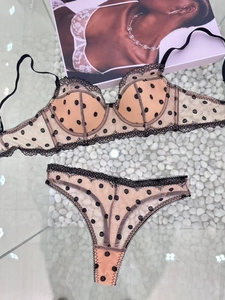 Flat lay of polka dot lace lingerie set with mesh fabric and black trim details
