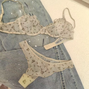 Detail showing the thin floral lace fabric and material label on an apricot bra set