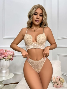 Detail of nude lace lingerie set with white animal print and deep U-back design
