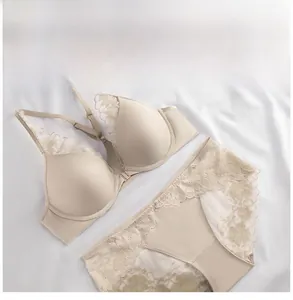 Close-up of front-closure lace bra and panties set in beige with floral embroidery