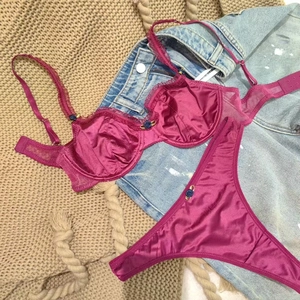 Detailed flat lay of berry lace lingerie set with satin finish and floral accents