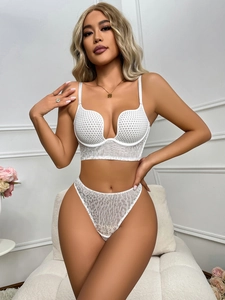 Detail of white lace leopard lingerie set featuring deep V-neck bra and thong