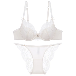 Close-up of cream lace lingerie set featuring silk satin panels and bow shoulder details