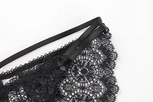 Detailed macro view of black floral lace underwear with satin bow and 100% cotton lining