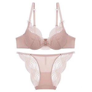 Flat lay of lace bra set with bow pendant detail on a white background