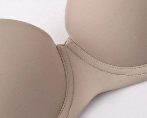 Macro detail of nude seamless bra cup with fine vertical texture and premium stitching