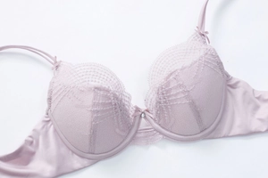 Detail of lavender floral lace bra with central bow, rhinestone and double satin straps
