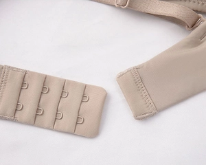 Close-up of seamless nude bra back featuring four-row hook closure and adjustable straps