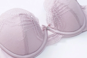 Close-up of lilac lace bra cup with center silk bow and crystal pendant detail
