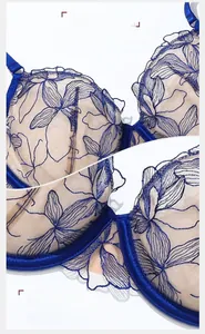 Dettaglio del ricamo floreale blu scuro e bordi smerlati delicati sul reggiseno