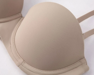 Macro shot of seamless skin-tone bra showing fine twill fabric texture and stitching detail