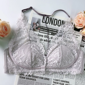 Detail of elegant French lace bralette on vintage paper with soft pink roses background