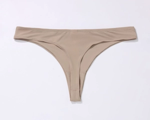 Detail of seamless beige thong featuring high-stretch fabric and reinforced breathable crotch