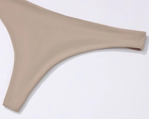 Detail of nude seamless microfiber bra fabric with smooth elastic hem and premium stitching