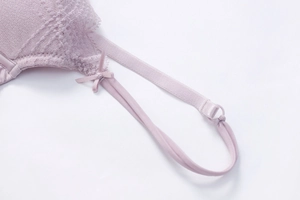 Macro detail of lavender floral lace bra featuring a delicate ribbon bow and adjustable strap