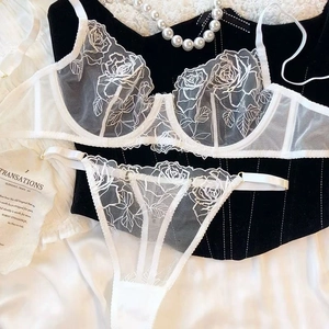 Detail of white mesh bra set with delicate rose embroidery and fine lace texture