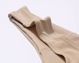 Macro detail of nude seamless bra featuring professional zigzag stitching and elastic fabric