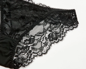Detailed macro view of black floral lace and smooth elastic fabric on lingerie briefs
