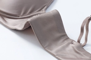 Detailed close-up of champagne satin fabric and seamless side wing on wire-free bra