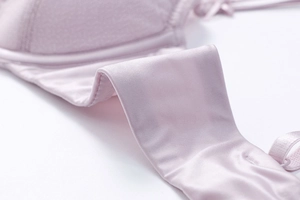Macro shot of smooth lavender pink silk fabric and seamless stitching on this lace bra