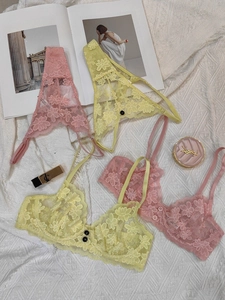 Flat lay of floral lace lingerie set with mesh details on a textured white fabric background