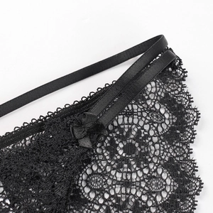 Lace underwear with sheer mesh and satin bow detail in black on a white background