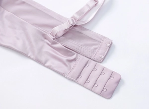 Close-up of lilac lace lingerie back featuring four-row hook-and-eye closure and mesh wings