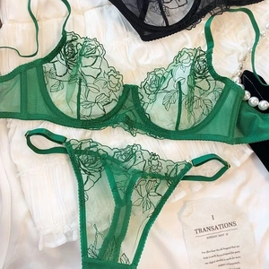 Detail shot of green lace lingerie set with rose embroidery and gold buckles