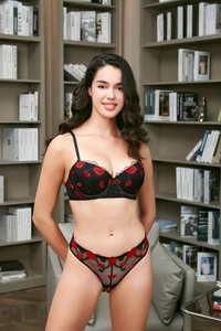 Detail of black lace lingerie set with vibrant red lip embroidery and scallop edges