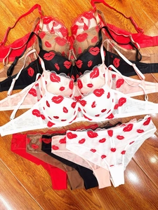 Detailed flat lay of lace lingerie sets with lip embroidery in five vibrant colors