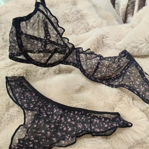 Detailed view of floral mesh lingerie set with pink flowers and ruffled trim on fur background