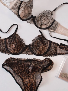 Dettaglio completo di set intimo in pizzo leopardato con mesh trasparente su bianco