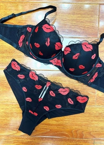 Detail of red lip embroidery on black lace mesh bra and panty lingerie set