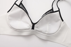 Detail of white lace bra with black contrast trim and delicate thin shoulder straps