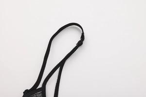 Detail of adjustable black shoulder straps and delicate floral lace on a wireless bra