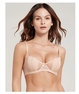Detail of light pink French lace bra with intricate patterns and small central bow