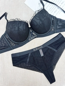 Detail of black lace lingerie with rose embroidery and elegant rhinestone lettering