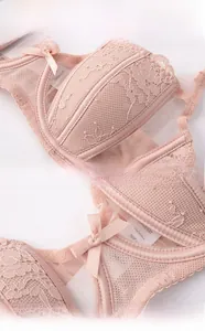 Detail view of pink lace bra cup showing soft mesh fabric and delicate bow decoration