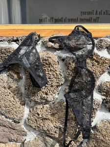 Détail d'un ensemble de lingerie en dentelle florale noire sur un fond de pierre brute