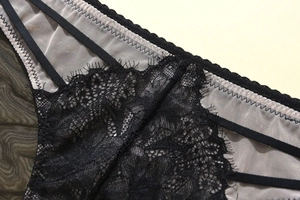 Detailed close-up of intricate black floral lace and breathable mesh on low waist panties