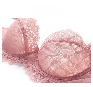 Detailed macro view of pink lace bra featuring intricate floral patterns and eyelash trim