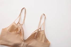 Detail of adjustable double straps and back hook closure on a seamless lace bra