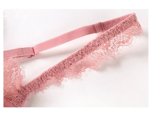 Close-up of pink French eyelash lace detail and adjustable strap on a sexy bra