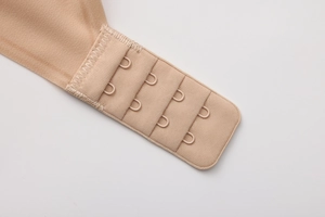 Close-up of four-row adjustable hook and eye closure on beige lace bra back strap