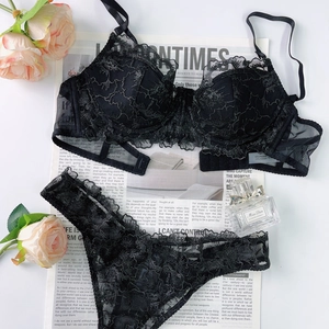 Ensemble de lingerie en dentelle florale noire avec broderie élégante sur fond de journal