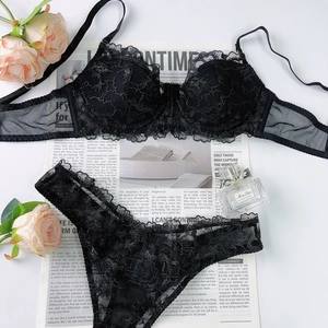 Détail d'un ensemble de lingerie en dentelle noire brodée sur fond de papier journal