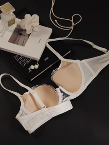 Détail d'un soutien-gorge en dentelle blanche avec ailes en mesh et perles élégantes