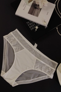 Vue à plat de lingerie en dentelle blanche avec mesh transparent et broderies délicates